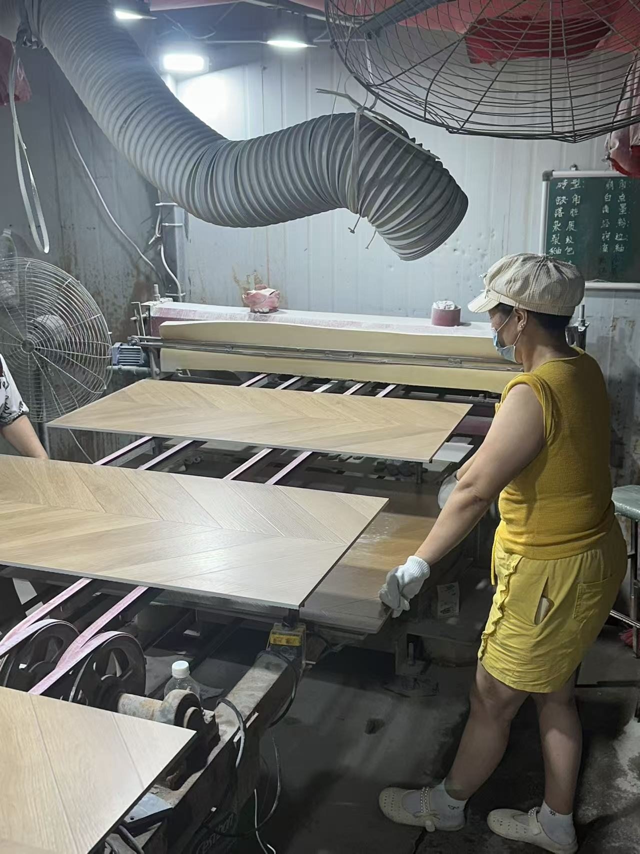 YiRong operator reviewing wood-look tile during production